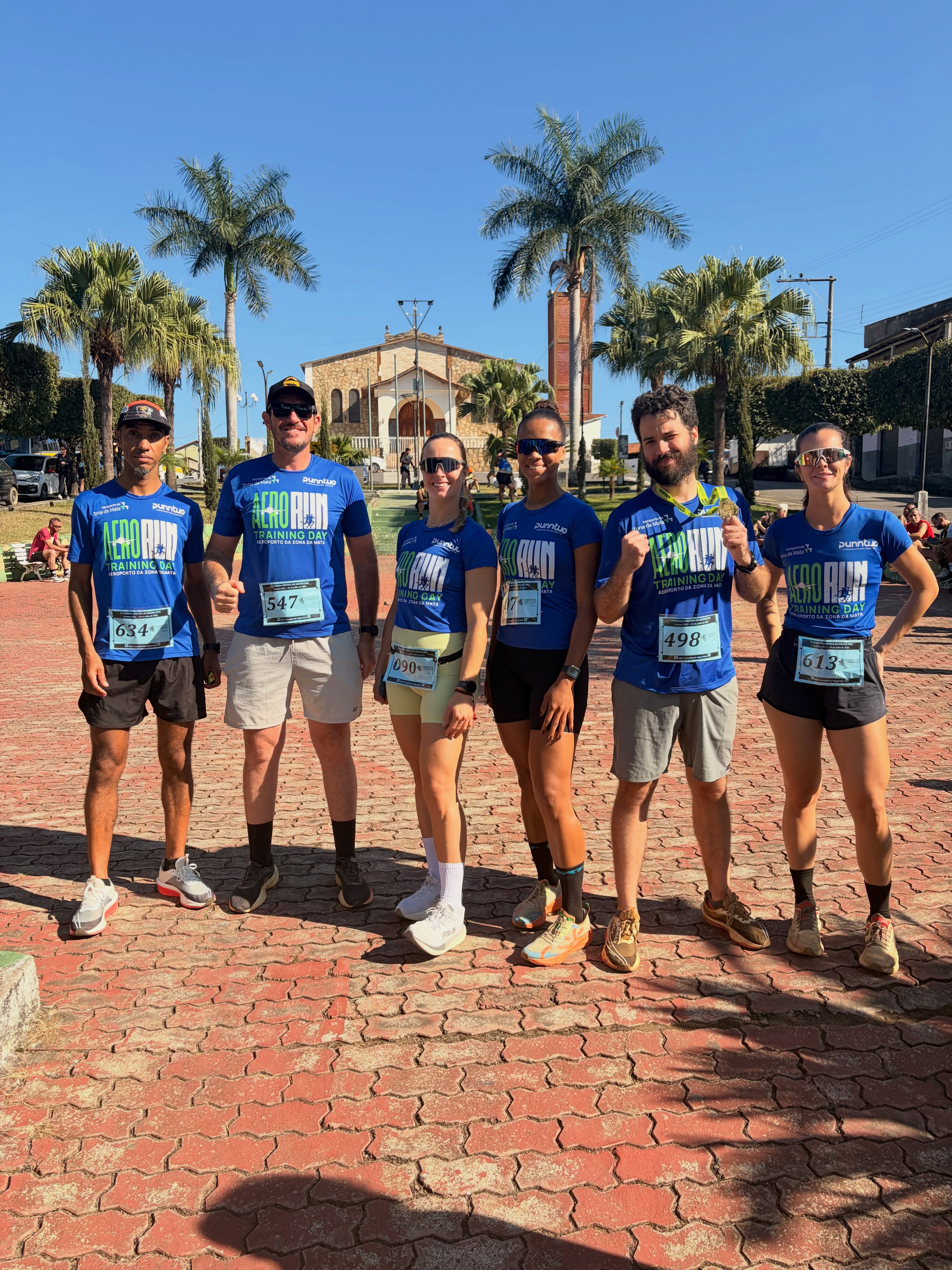 Grupo de atletas uniformizados pela Punntuo posando após corrida